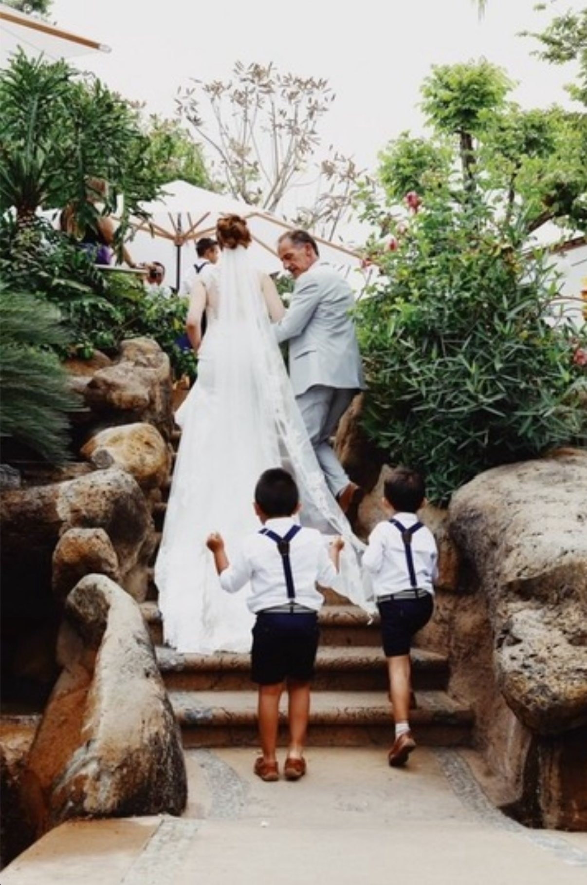 Novia subiendo escalinata rodeada de jardines